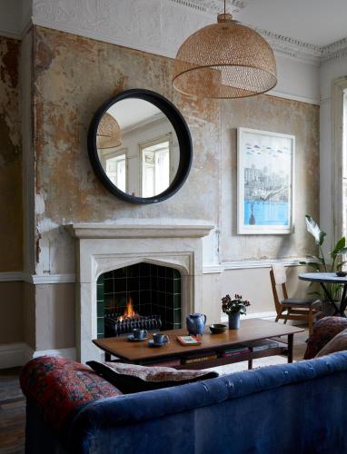 a living room with a couch and a fireplace at Artist Residence Bristol in Bristol