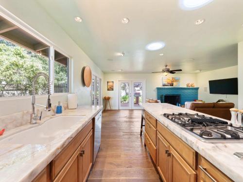 a kitchen with a sink and a stove at Azure Grove - Pebble Beach Tranquility for a Family of 8 in Pebble Beach