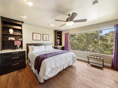 a bedroom with a bed and a window with purple curtains at Azure Grove - Pebble Beach Tranquility for a Family of 8 in Pebble Beach