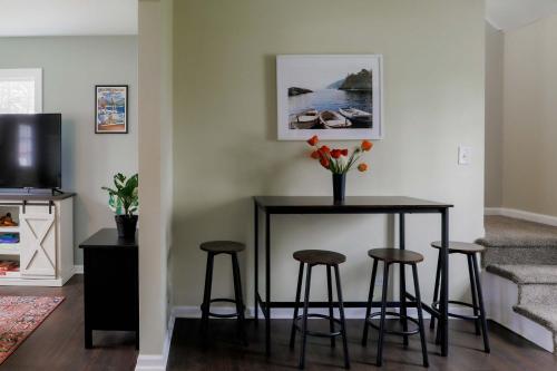ein Esstisch mit Hockern und ein Tisch mit Blumen in der Unterkunft Your Cozy Lockwood Lodge Awaits Pet Friendly in Lake Geneva