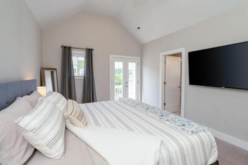 a bedroom with a large bed and a flat screen tv at Cumberland Emerald - Walk to Dining in Old Hickory