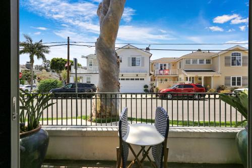 two chairs and a tree in front of a fence at Poinsettia Palms - Chic & Luxe Patio Near Beach in Corona del Mar