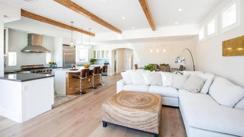 a living room with a white couch and a kitchen at A True Vacation Masterpiece in Corona del Mar