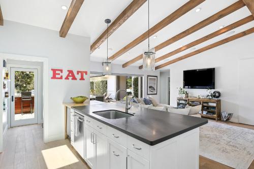 a kitchen with a sink and a living room at Private Wading Pool Home with Patio in Corona del Mar