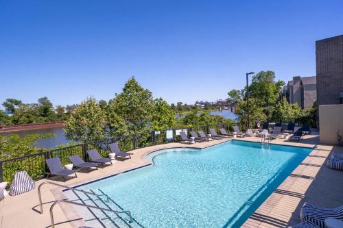 a swimming pool with lounge chairs and a river at Riverfront Condo in DT in Nashville
