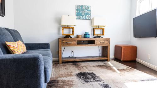 Una sala de estar con un sofá y un televisor. en Balboa Escape An Iconic Stay, en Newport Beach