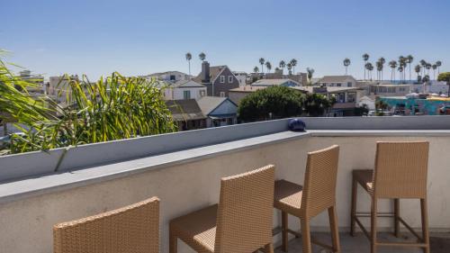a row of chairs on a balcony with a view of a city at Balboa Escape An Iconic Stay in Newport Beach
