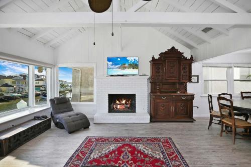 a living room with a fireplace and a table at Grand Canal Getaway - Balboa Island in Newport Beach
