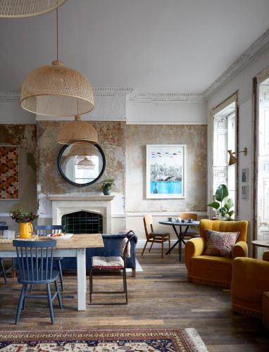 a living room with a table and a fireplace at Artist Residence Bristol in Bristol