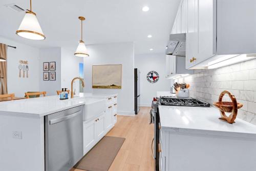 a white kitchen with white counter tops and appliances at Chic Modern Farm Haus - Minutes to Everything in New Braunfels