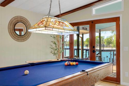 a pool table in a living room with a chandelier at Beautiful and Relaxing Lakefront Getaway in New Braunfels