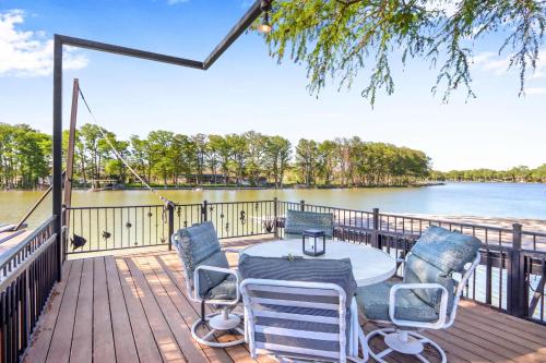 a table and chairs on a deck with a view of the water at Amazing Lakefront Escape - A Stunner For Sleeps 14 in New Braunfels