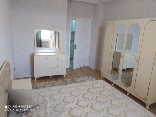 a living room with a mirror and a dresser at квартира на аренду in Sumqayyt