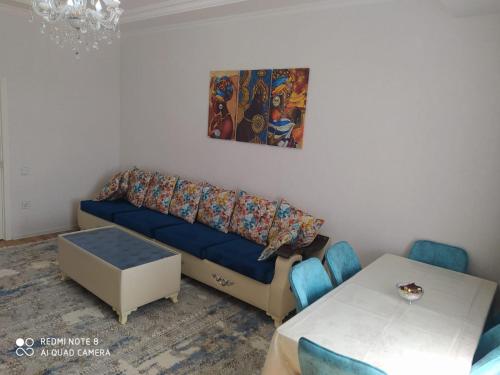 a living room with a blue couch and a table at квартира на аренду in Sumqayyt
