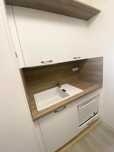La salle de bains est pourvue d'un lavabo dans une armoire blanche. dans l'établissement Résidence Le Bois D'aurouze - Studio pour 4 Personnes MAE-8684, à Saint-Étienne-en-Dévoluy