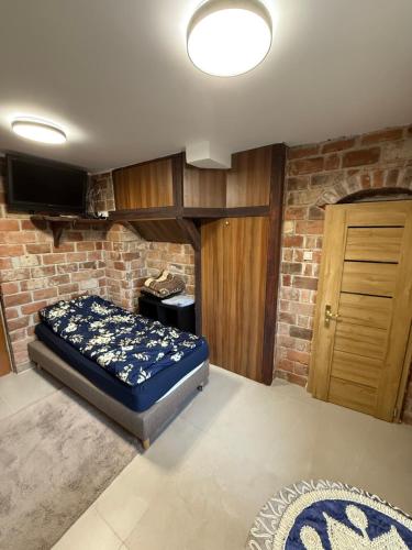 a bedroom with a bed and a brick wall at Agroturystka Jaśkowo 