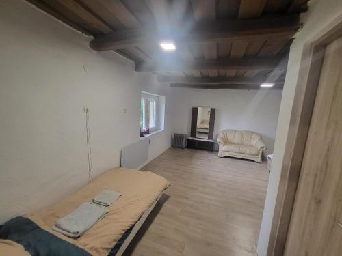 a room with a bed and a chair in it at Enikő Vendégház in Vajdácska