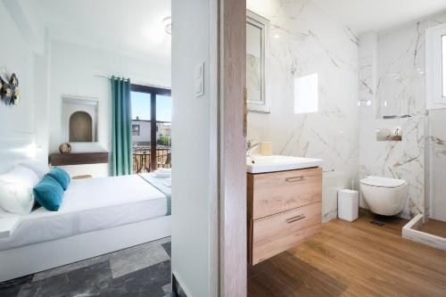 a white bathroom with a sink and a toilet at Anastasia Veridian Living in Kalathas