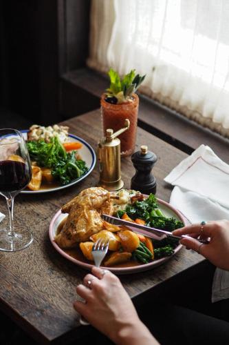 a table with two plates of food and a glass of wine at Artist Residence Bristol in Bristol