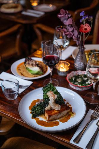 a table with plates of food and glasses of wine at Artist Residence Bristol in Bristol