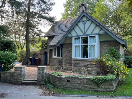 a small house with a window on a stone wall at Park Lodge with Hot Tub in Glossop