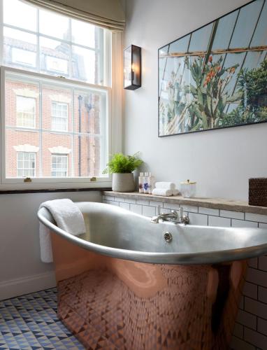 a bath tub in a bathroom with a window at Artist Residence Bristol in Bristol