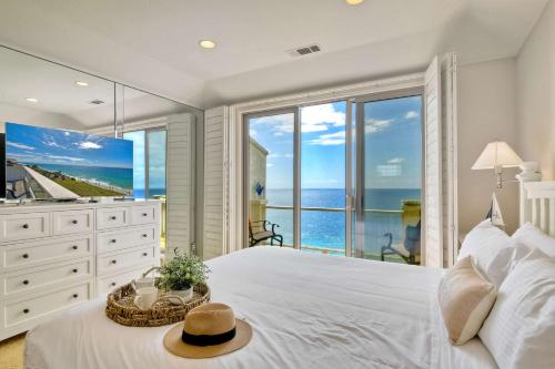a bedroom with a white bed with a view of the ocean at Beachfront Sunset in Encinitas