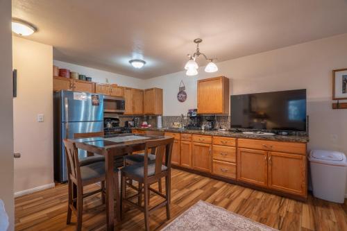 Una cocina con refrigerador y una mesa con sillas. en Birch Creek #1 - 1BR/1BA - Down Canyon, en June Lake