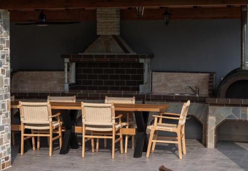 a wooden table and chairs in front of a fireplace at Bianca's House in Nikiti