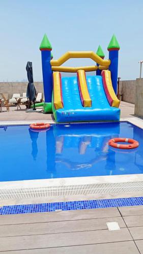 a water slide in a pool at a water park at Abraj INN Royal Hotel فندق أبراج إن الملكي in Doha