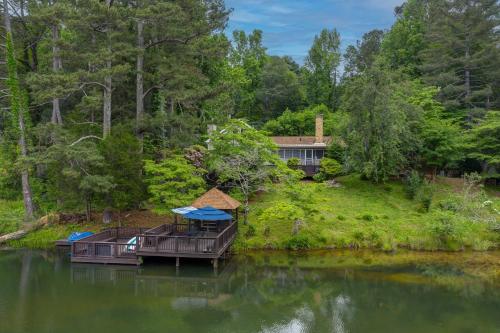 una casa en un río con un barco en el agua en Lakefront Home with Private Dock - in Jasper GA, en Talking Rock