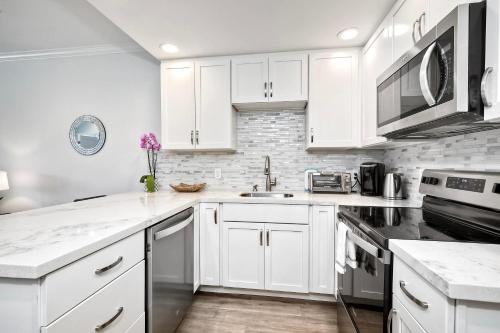 a white kitchen with white cabinets and appliances at La Costa Gem - Condo for 3 in Carlsbad