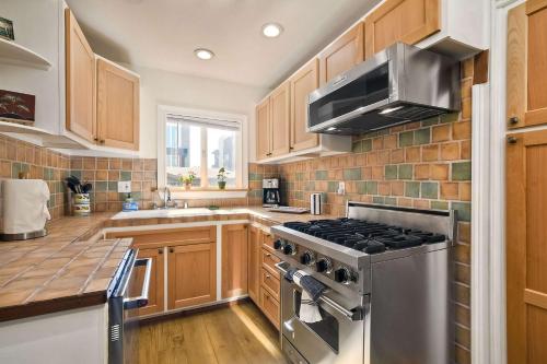 eine Küche mit Holzschränken und einem Edelstahlherd in der Unterkunft Vintage Beach Bungalow - For 6 in Oceanside