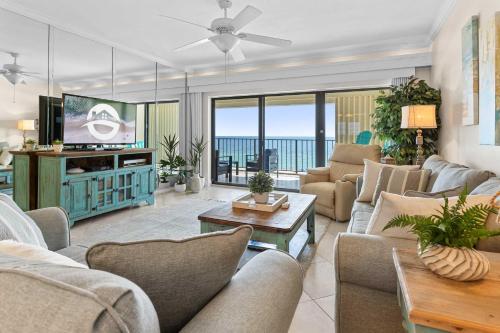 a living room with a couch and a tv at Spacious Beachfront Retreat - Sauna Pools & More in Perdido Key