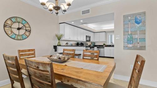 a kitchen and dining room with a wooden table and chairs at Spacious Beachfront Retreat - Sauna Pools & More in Perdido Key