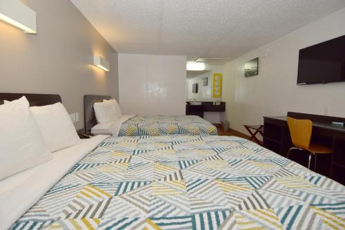 a hotel room with a bed and a tv at Motel 6-Hamburg, NY in Hamburg