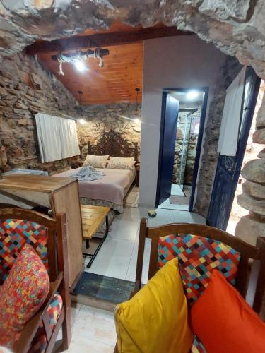 a room with a bed and a table and chairs at Pousada Casa do Arco in Santana do Riacho