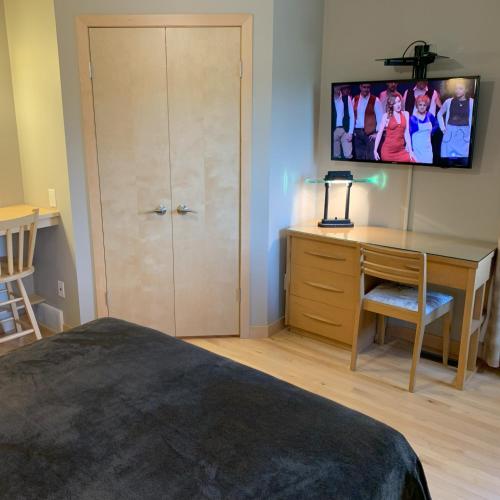 a bedroom with a desk and a desk with a computer at Aspen Woodlands Bed and Breakfast in Winnipeg