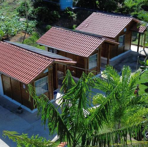 an overhead view of two cottages with red roofs at Pousada Hostels Foryou in Ibiraçu