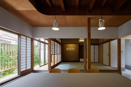 a room with a table and chairs and windows at Otsu Guesthouse Seiseki - Vacation STAY 90442v in Otsu