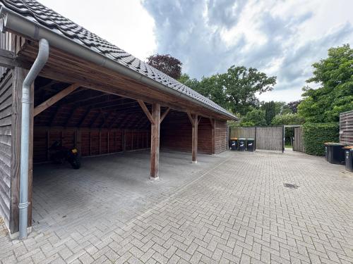 a large brick building with a roof with a patio at Slapen an de Veenvaart in Nieuw-Amsterdam