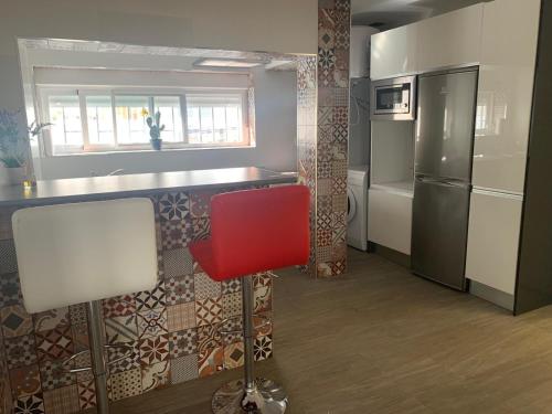 kuchnia z czerwonym krzesłem i lodówką w obiekcie Vivienda Turística Níjar w mieście Níjar