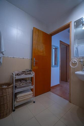 a bathroom with a sink and a door with towels at Piso Playa de Canet in Canet de Berenguer