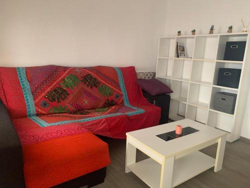 salon z czerwoną kanapą i stołem w obiekcie Vivienda Turística Níjar w mieście Níjar
