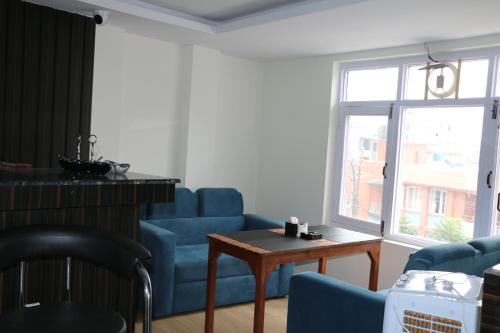 un soggiorno con sedie blu, tavolo e finestra di Hotel Bharosa Inn a Kathmandu