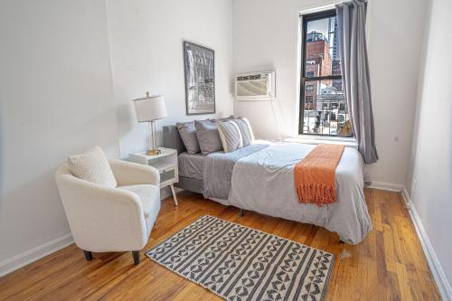 a bedroom with a bed and a chair and a window at Chic 2BD Upper East Side Retreat in New York