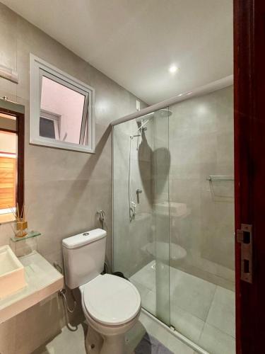 a bathroom with a toilet and a glass shower at CANOA - Boas Vistas in Canoa Quebrada