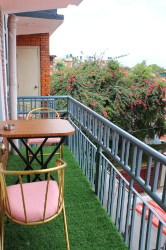 una mesa y sillas en un balcón con césped en Hotel Bharosa Inn, en Katmandú