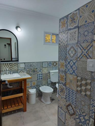 a bathroom with a toilet and a sink and a mirror at Cabañas Finca del molino in Panaholma