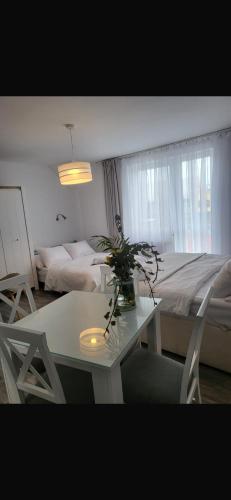 a living room with a table and a bed at Pokoje 100 m od morza in Dziwnów